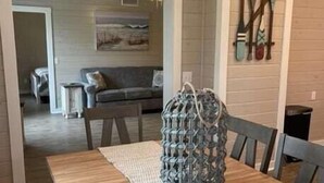 A dining area with a wooden table, a woven placemat, and a woven bag on the table. - Riverside 3BR Retreat | Tranquil & Family-Friendly (Indian River)
