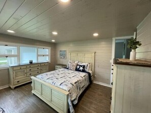 Une chambre à coucher avec un lit, une commode et une fenêtre.