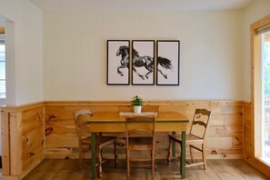 Ein Essbereich aus Holz mit einer Bank, einem Tisch und drei Stühlen.