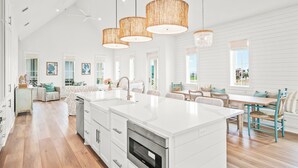 A spacious kitchen with a large island, white cabinetry, and a modern design.