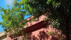 A building with a red facade, a balcony, and a door. - Suites el Consuelo (Oaxaca)