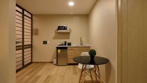 A compact kitchen with a microwave, sink, and refrigerator. - Suites el Consuelo (Oaxaca)