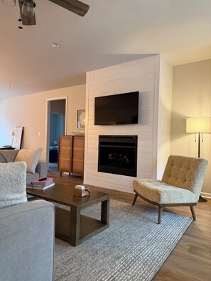 Relax in this cozy living space with a flat-screen TV, fireplace, and comfortable seating area.