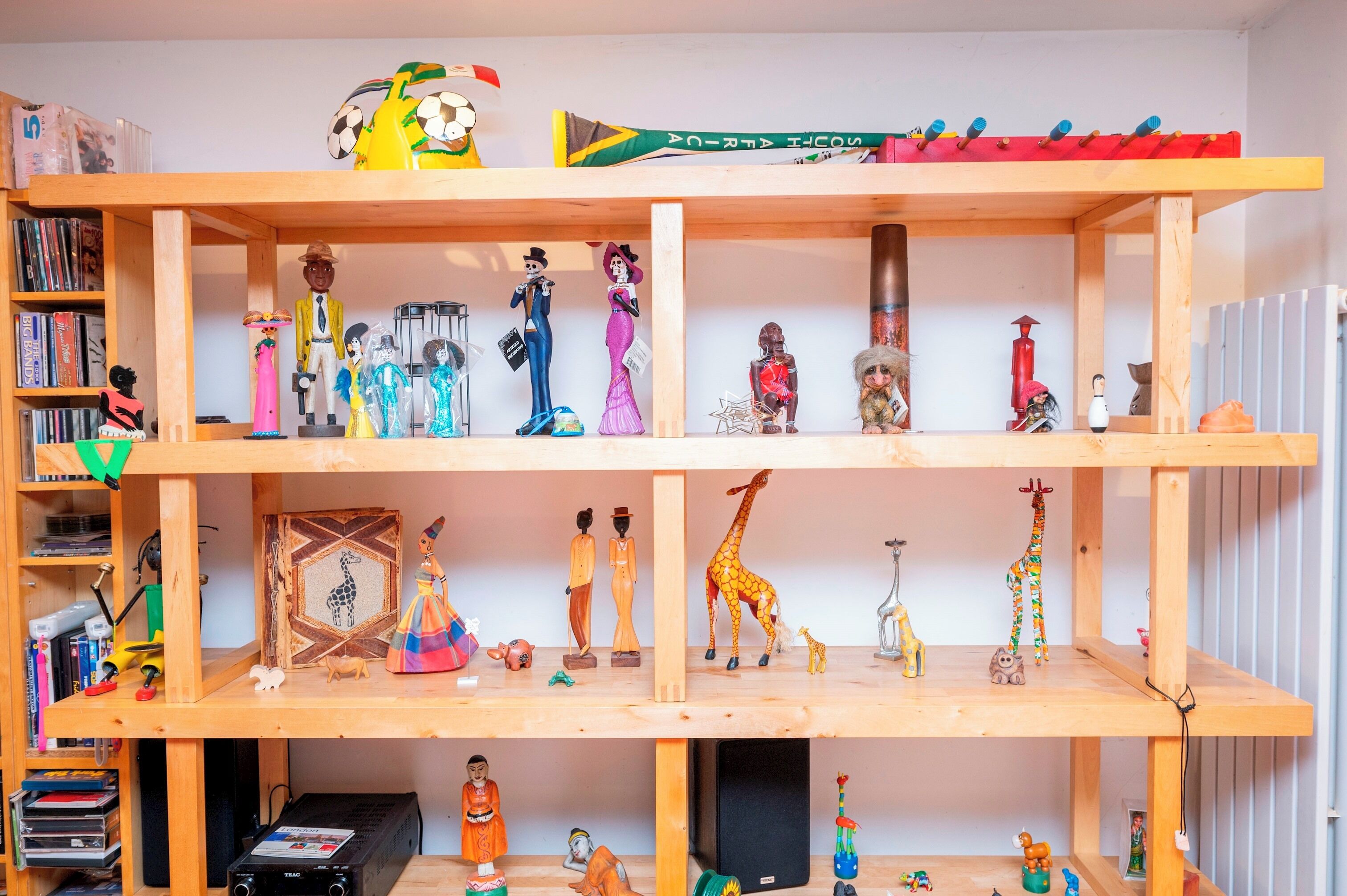A wooden shelf with various figurines and decorative items.