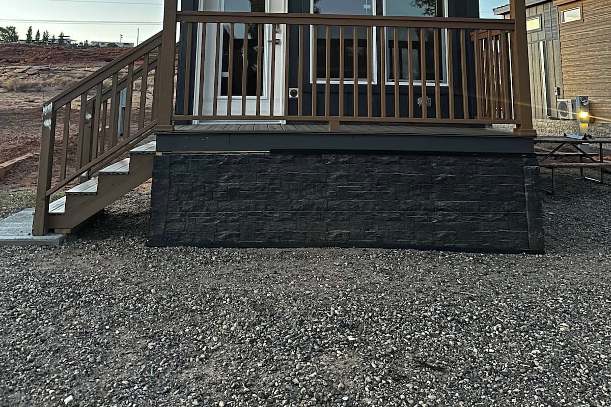Un petit bâtiment doté d’un porche, d’un escalier et d’une base en pierre.
