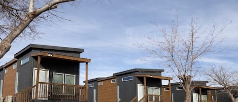 A row of modern, two-story cabins with wooden balconies and large windows.