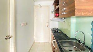 Una cocina con estufa, lavaplatos y armarios de madera.