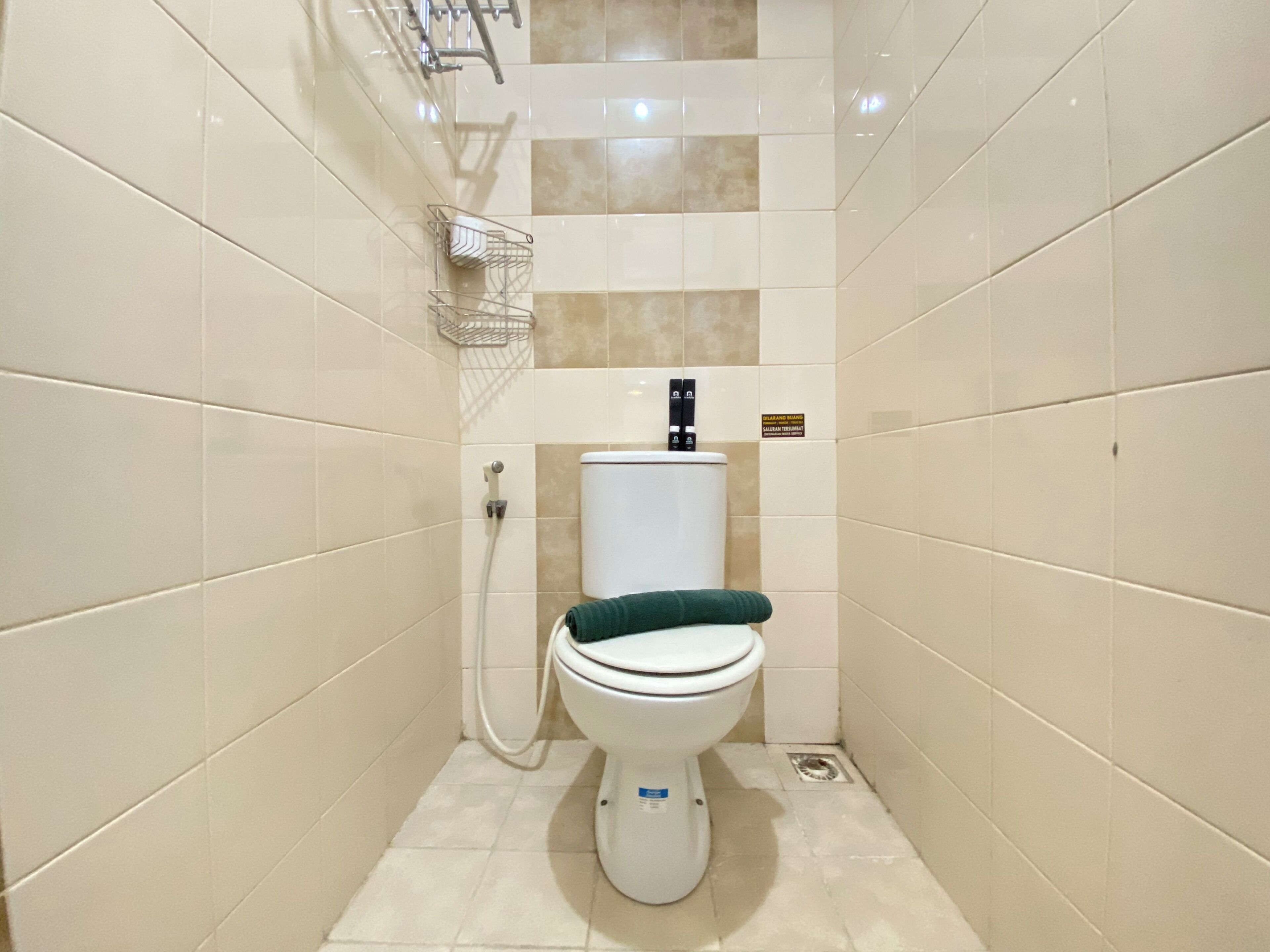 Un baño pequeño y moderno con inodoro blanco, ducha y piso de baldosas.