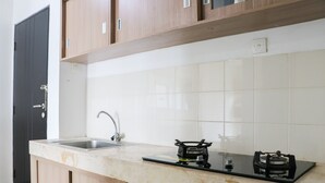 Una cocina con mostrador, pileta y cocina a gas.