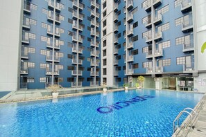 A modern building with a pool area. - Simply And Homey Studio At Evenciio Margonda Apartment (Depok)