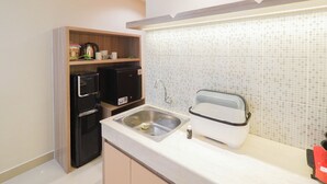 A compact kitchen with a built-in microwave, a toaster, and a sink.