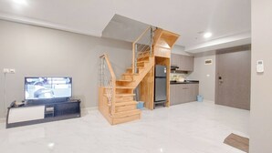 Una cocina moderna con armarios de madera, horno empotrado y refrigerador de acero inoxidable.