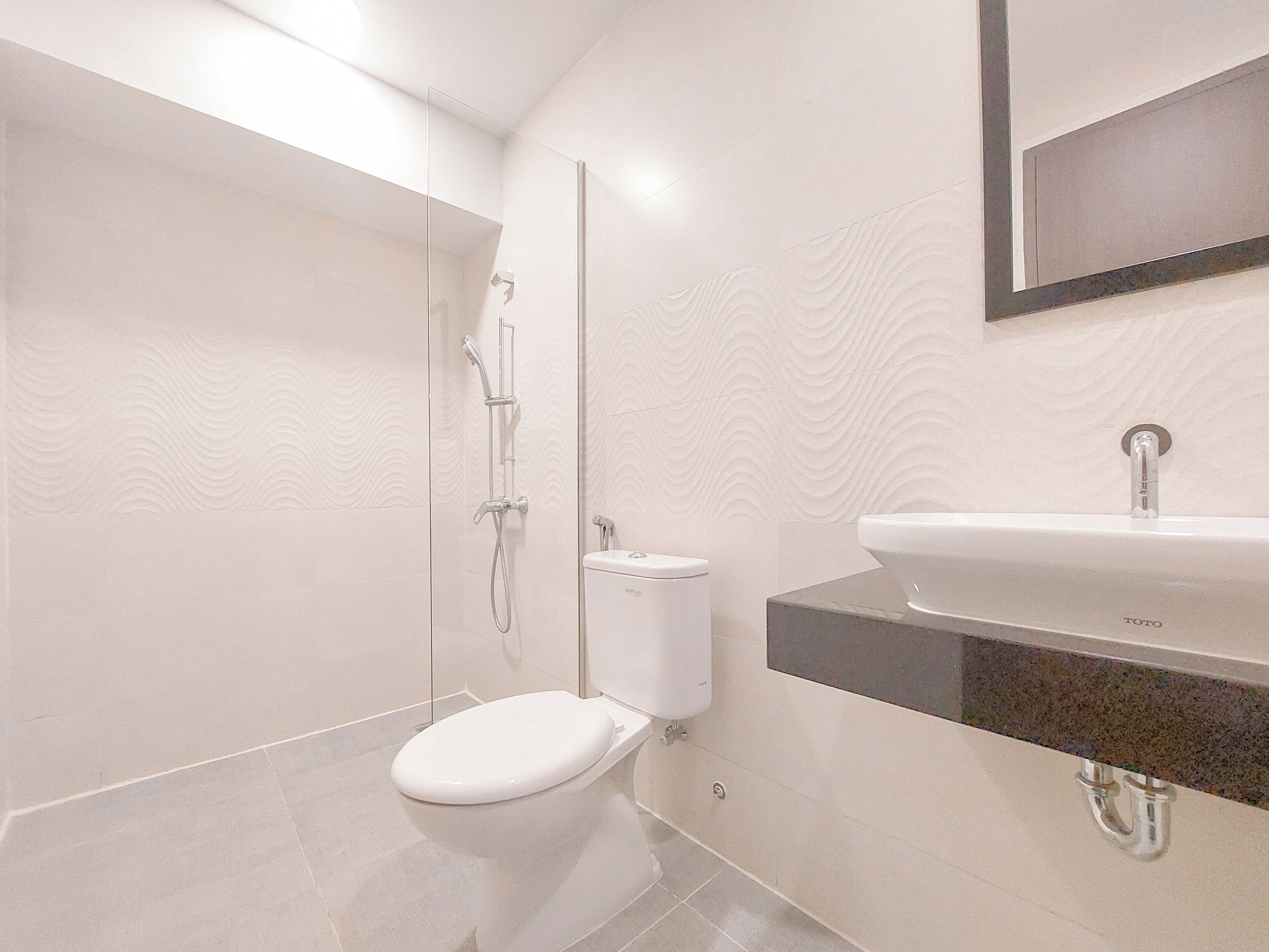 A modern bathroom with a toilet, a shower, and a sink.