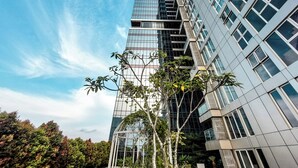 Un moderno edificio de gran altura con fachada de vidrio y varios balcones.