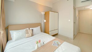 Une chambre d’hôtel avec un lit, une lampe de chevet, une armoire et une porte.