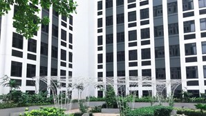 Ein modernes Gebäude mit weißer Fassade und zahlreichen Fenstern.