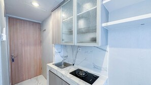Uma cozinha compacta com fogão a gás embutido, pia e armários de madeira.