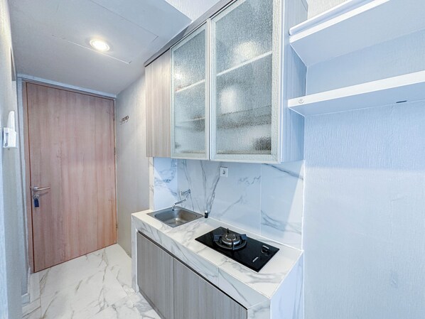 A compact kitchen with a built-in gas stove, a sink, and wooden cabinets.