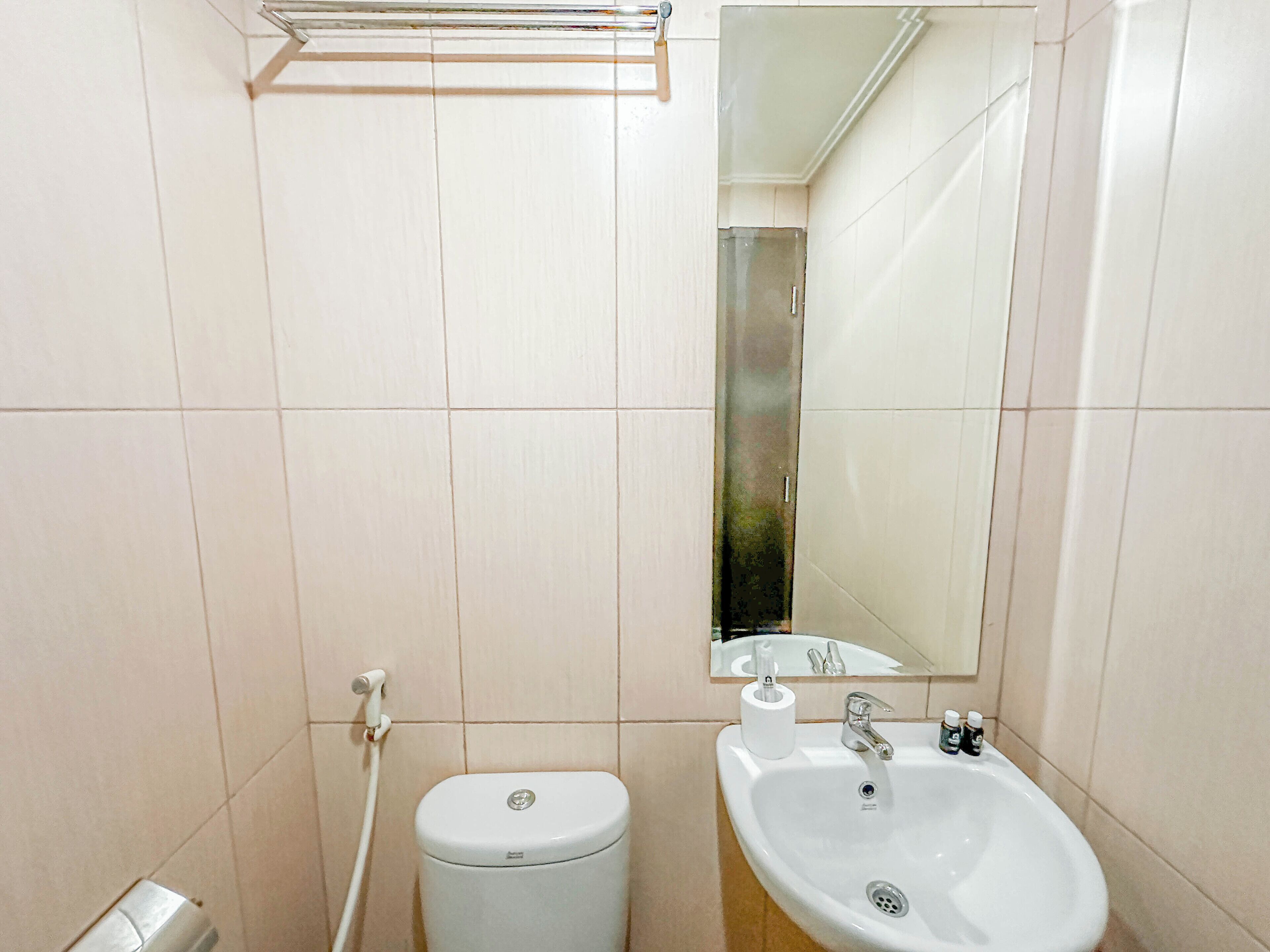 Une salle de bain avec des toilettes, un lavabo et un miroir.