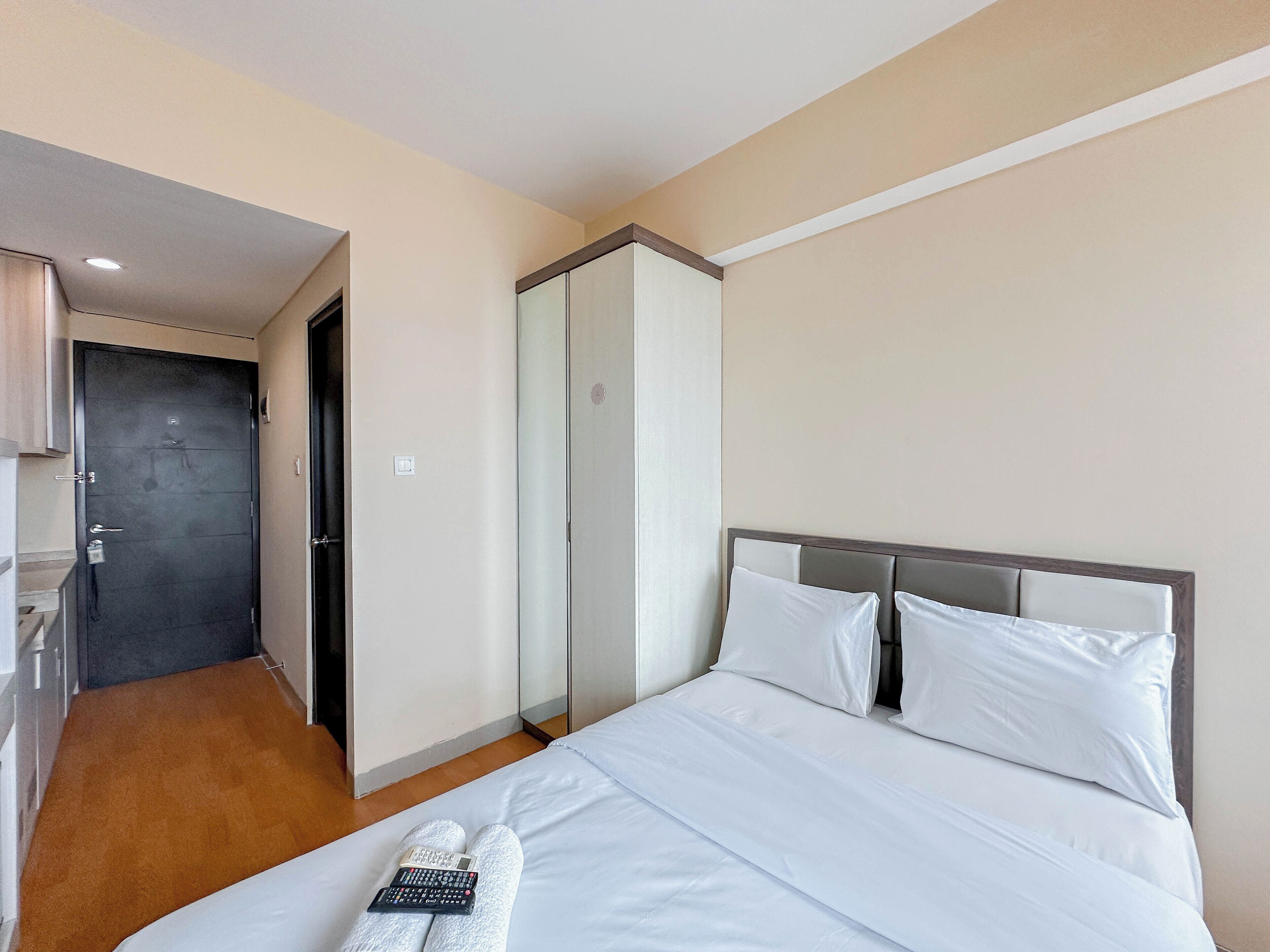 A hotel room with a bed, a wardrobe, and a bathroom.