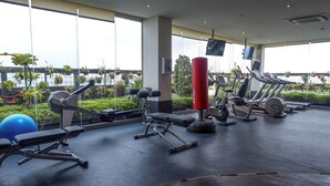 A gym with exercise equipment, large windows, and a view of greenery. - Elegant And Best Deal 1Br At L'Avenue Pancoran Apartment (Jakarta)