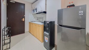 Eine kleine Küche mit einem Kühlschrank, einem Geschirrspüler und einem Waschbecken.