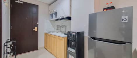 A compact kitchen with a refrigerator, a dishwasher, and a sink.