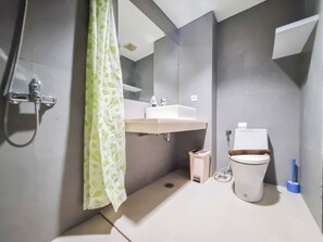Une salle de bain moderne équipée d’une douche, de toilettes et d’un lavabo.