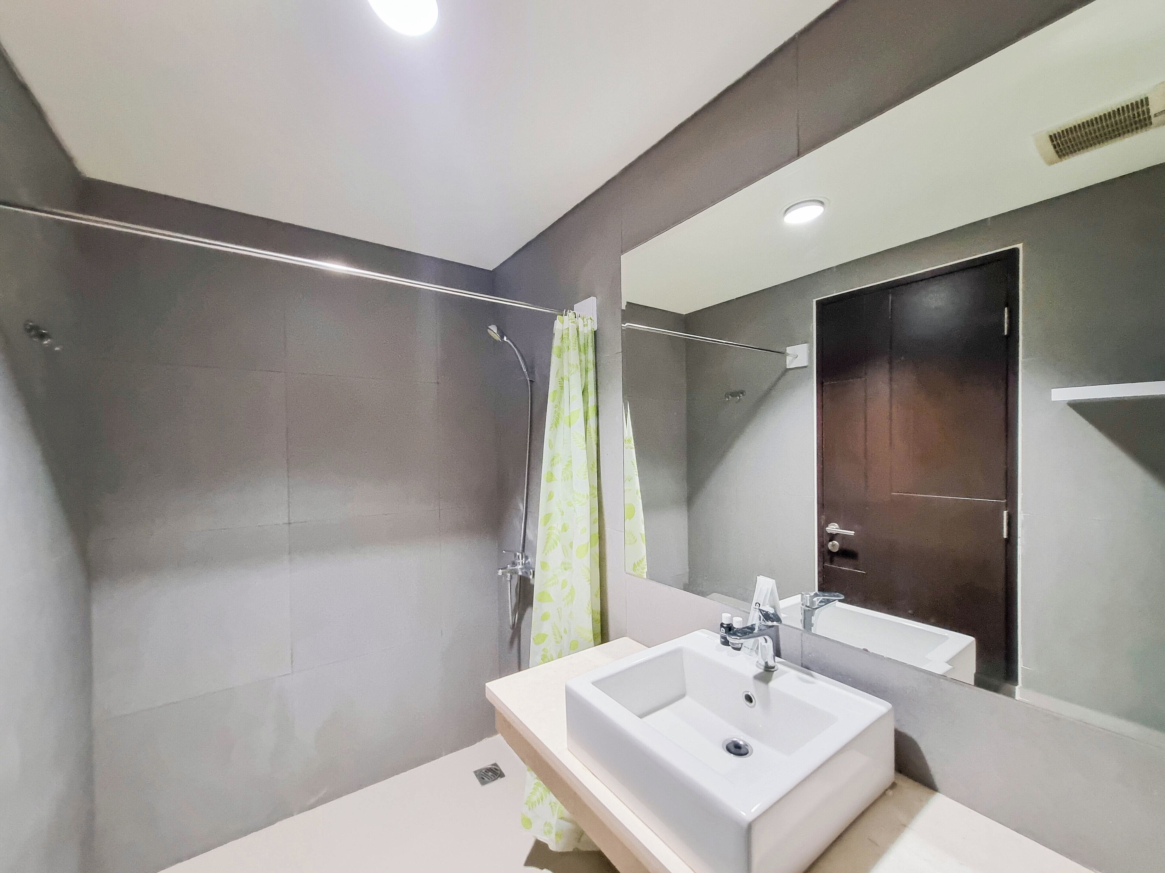 A modern bathroom with a shower, a sink, and a mirror.