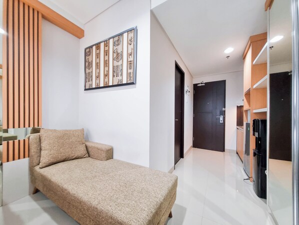 Un dormitorio moderno con cama, sofá, un panel decorativo y una puerta.