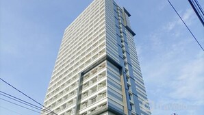 Un edificio alto y moderno con fachada de entramado y múltiples balcones.