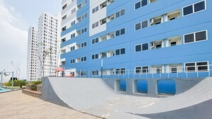 Ένα σύγχρονο κτίριο με πολλούς ορόφους, μεγάλα παράθυρα και μια καμπυλωτή κατασκευή από σκυρόδεμα στο προσκήνιο.