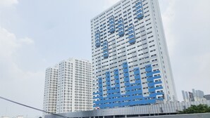 Ένα ψηλό κτίριο με πολλούς ορόφους και μια μεγάλη, χαρακτηριστική μπλε επιγραφή στην πλευρά του.