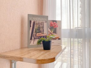 Ένα βιβλίο σε κορνίζα με τίτλο «Σκανδιναβικά Όνειρα» είναι τοποθετημένο πάνω σε ένα ξύλινο τραπέζι, δίπλα σε μια γλάστρα με φυτό.