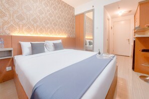 Cozy retreat with a large bed, wooden headboard, and a wardrobe with a mirror.