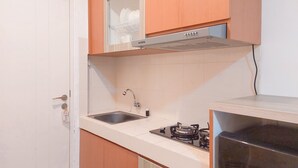 Una cocina con microondas integrado, estufa a gas y un lavamanos.