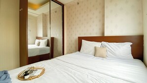 Ein Hotelzimmer mit einem großen Bett, einem Holz-Kopfteil und einem Spiegel an einer Wand.