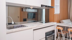 Eine moderne Küche mit Einbauofen, Mikrowelle und Spüle. Ein Essbereich mit Tisch und zwei Stühlen.