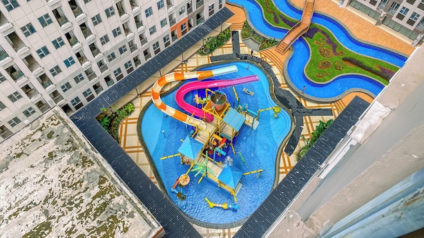 A rooftop pool with multiple water slides and a children's play area. - Great Deal And Homey Studio Apartment At Transpark Juanda Bekasi Timur (Bekasi)