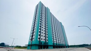 A tall, modern high-rise building with a uniform facade and a flat roof. - Cozy And Homey Studio At Riverdale Apartment (Cikarang)