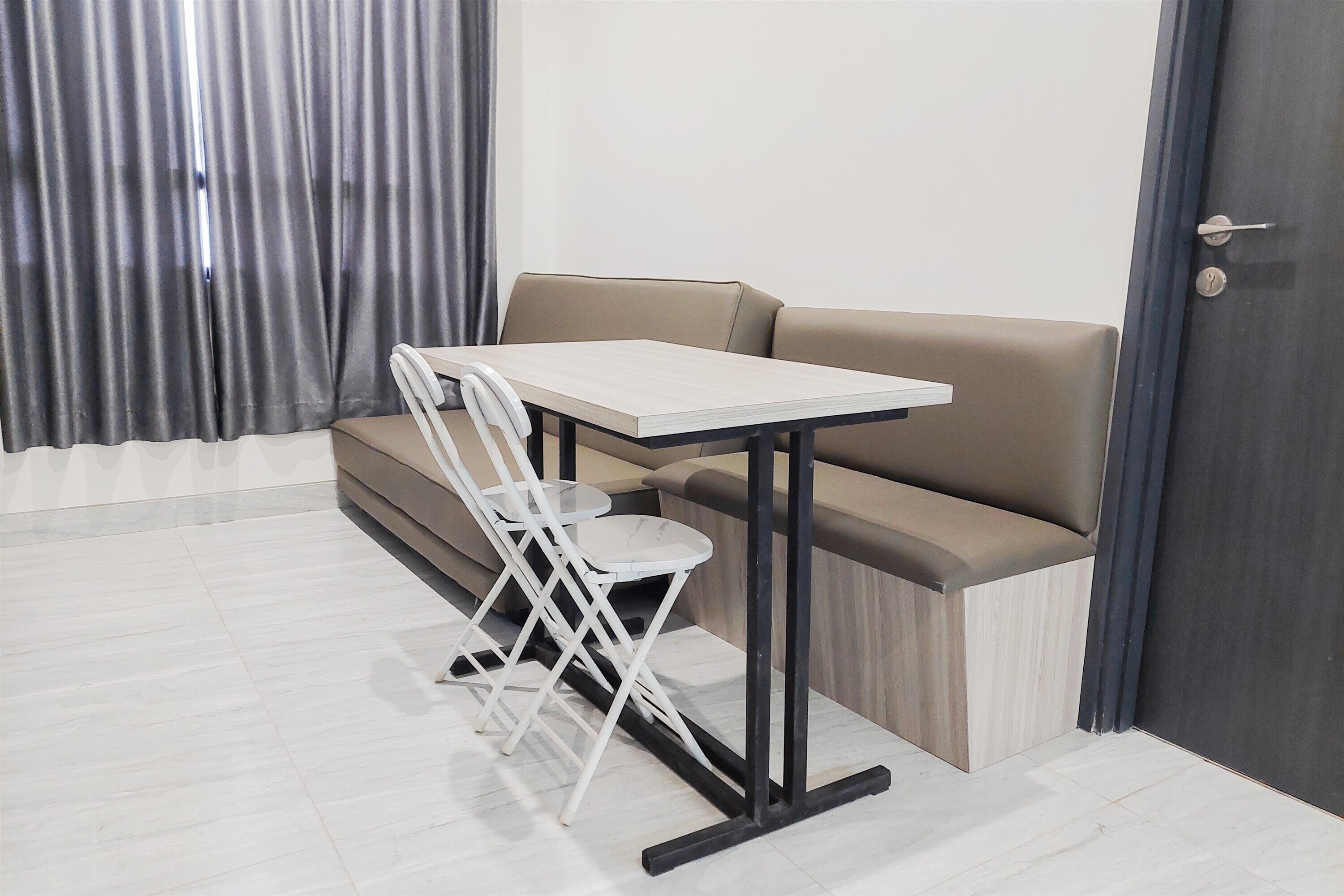 A room with a sofa, a small table, and a chair.