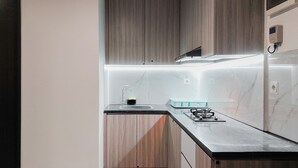 Una cocina moderna con armarios de madera, encimera negra, estufa a gas y pileta.