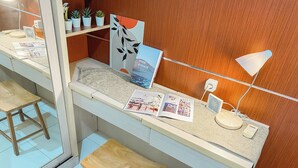 A modern kitchen with a wooden countertop, a stool, a magazine, and a lamp. - Good Place 2Br At Kebagusan City Apartment (Jakarta)