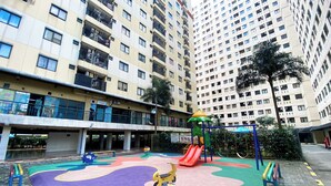 A playground with a slide and climbing structures, surrounded by apartment buildings. - Good Place 2Br At Kebagusan City Apartment (Jakarta)