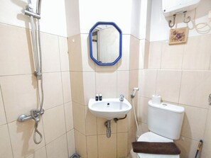 Une salle de bain équipée d’une douche, d’un lavabo, de toilettes et d’un miroir.