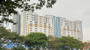 A multi-story residential building with a modern design, featuring a prominent "MATANA" sign on one of the buildings.