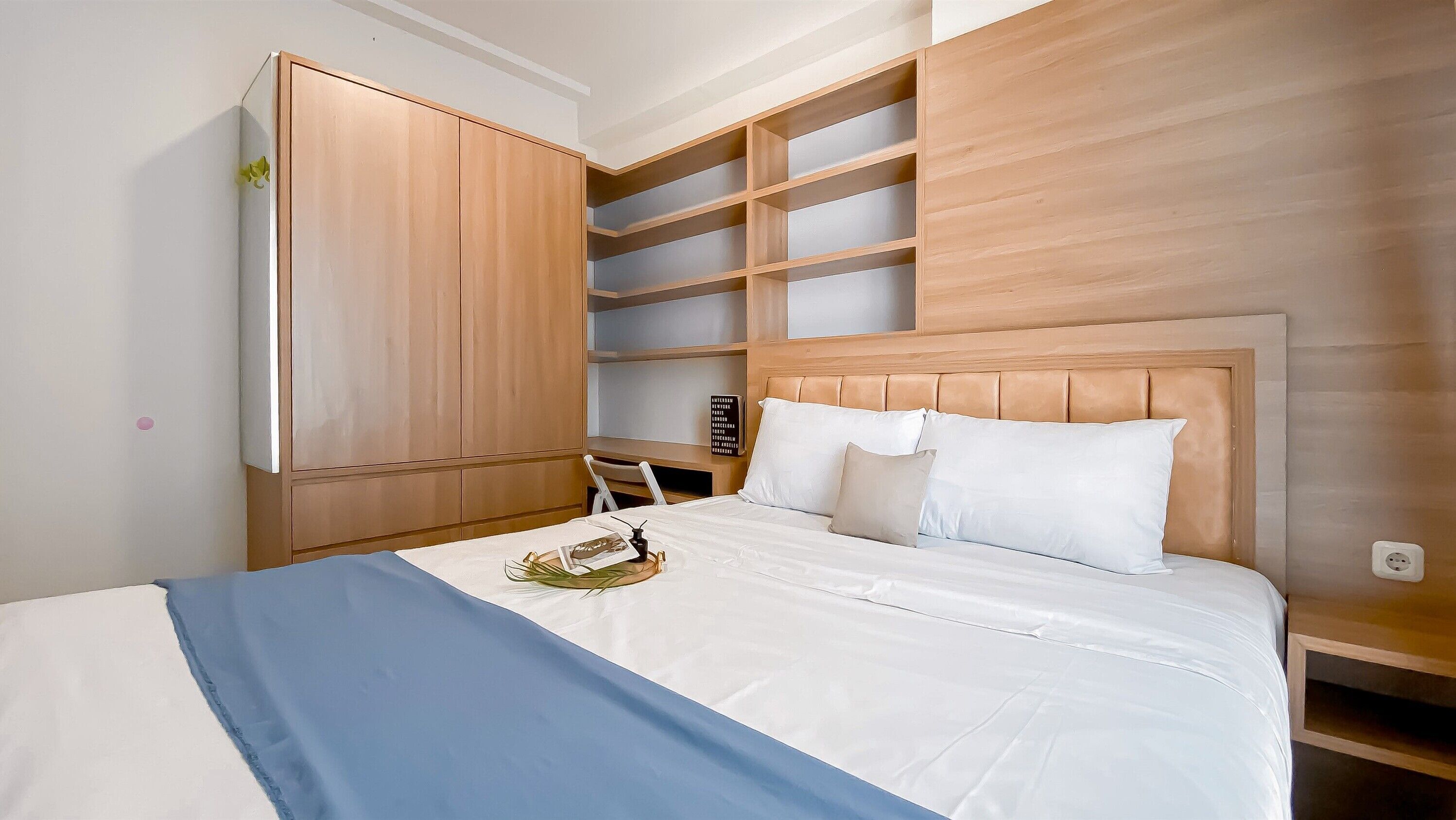 A bedroom with a bed, a wardrobe, and built-in shelves.