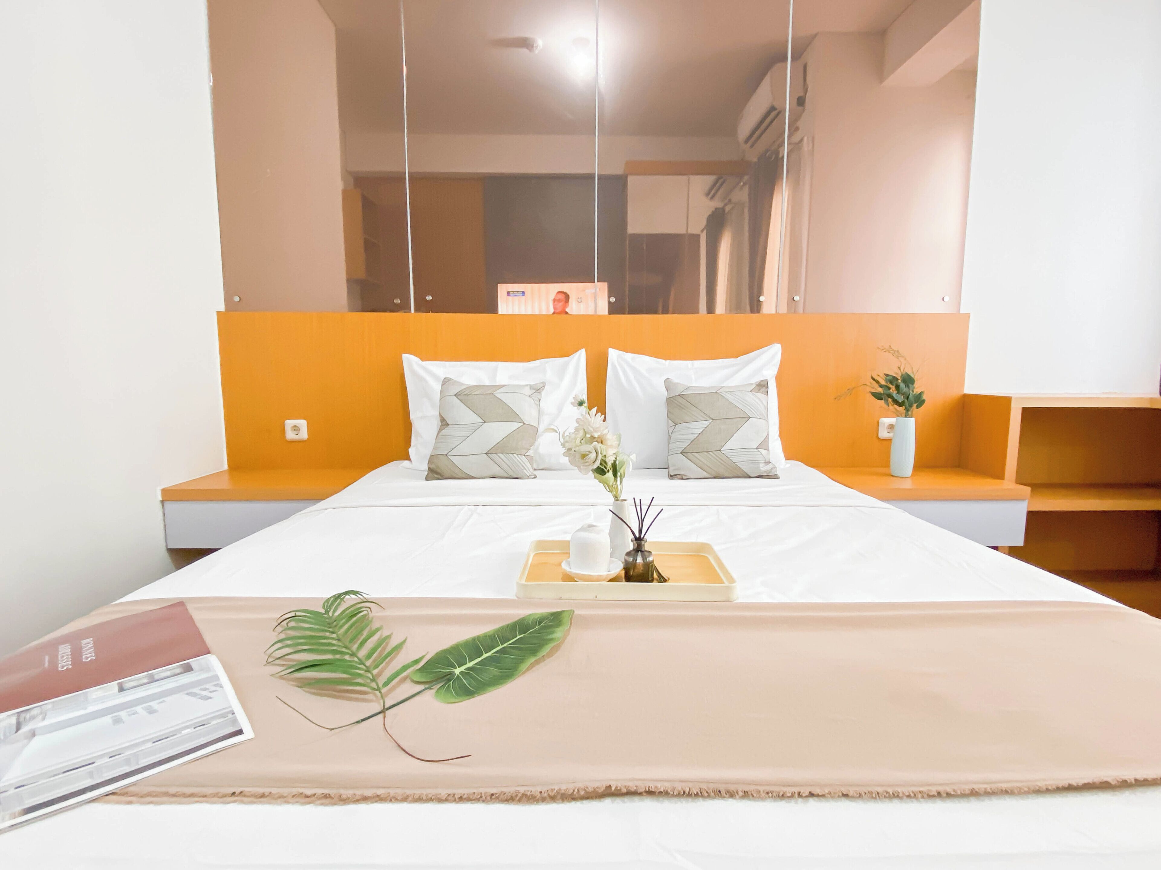 Une chambre d’hôtel bien aménagée, avec un lit, une table de chevet et un petit coin salon.