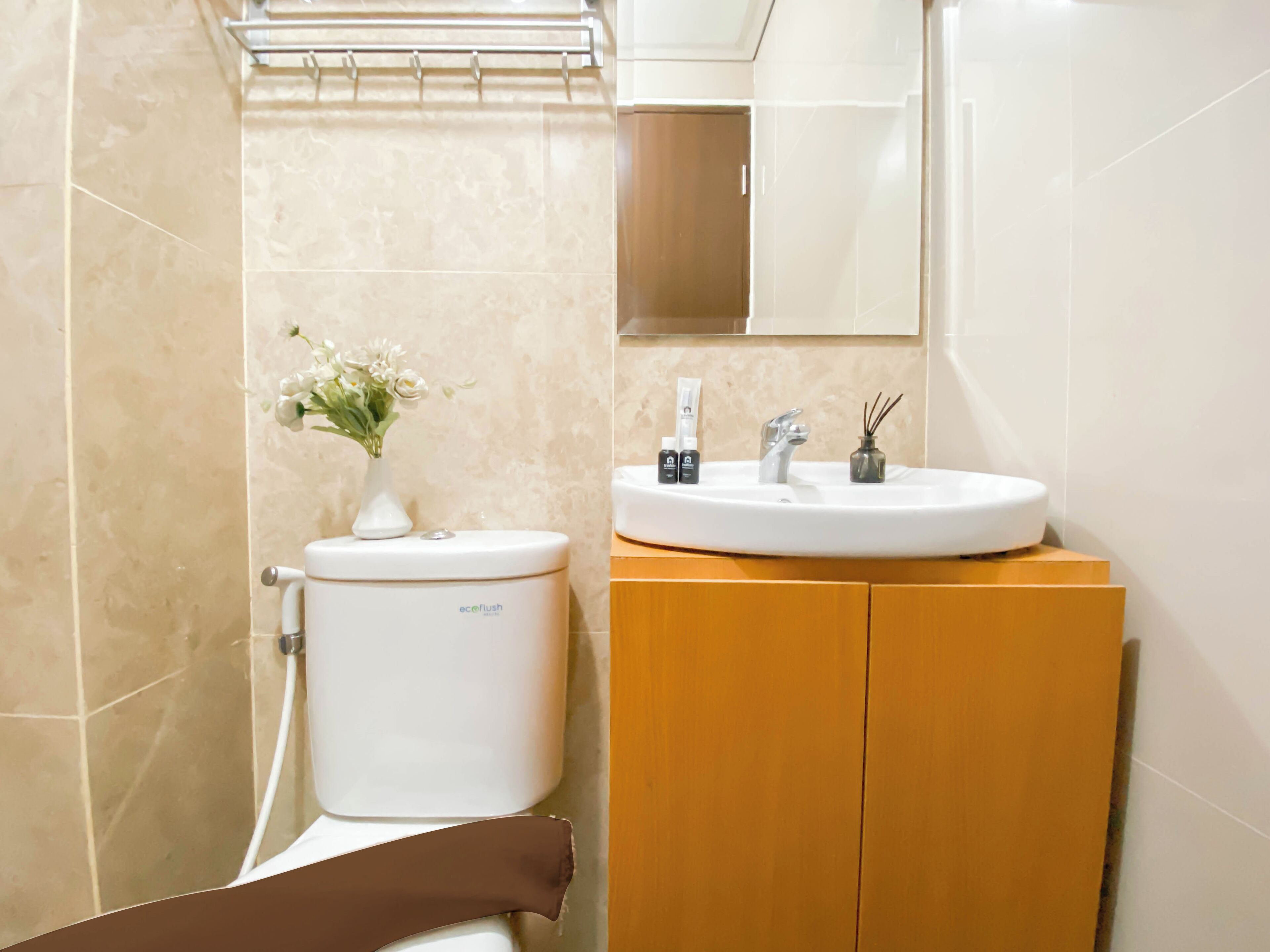 A bathroom with a toilet, sink, and mirror.