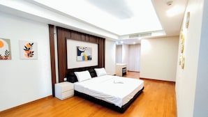 A modern bedroom with a large bed, a bedside table, a nightstand, a wardrobe, and a ceiling light. - 2Br Luxurious And Spacious Apartment At One East Penthouse Residence (Surabaya)